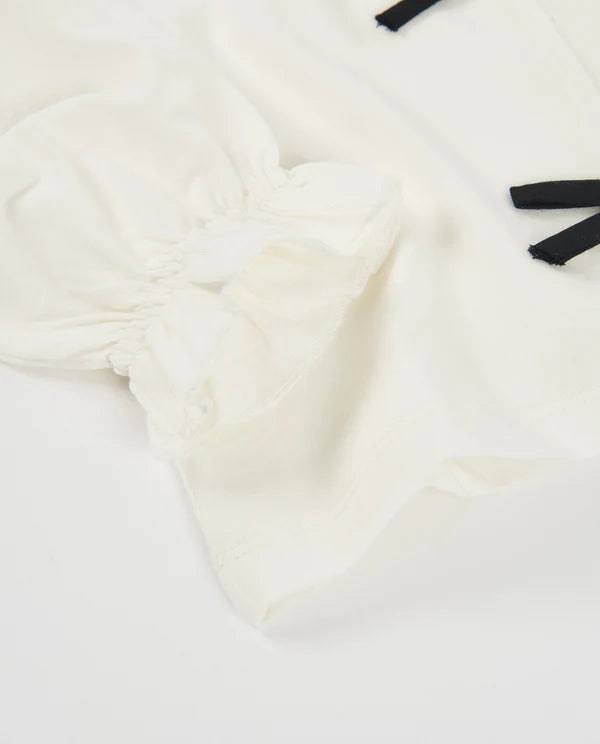 Maglietta da bambina in maglia con fiocchi sul davanti e polsini arricciati nath kids